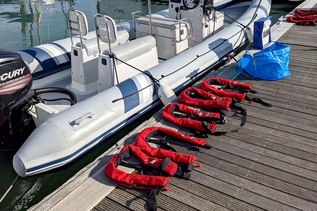 Lifejackets lined up on the pontoon next to the rental RIB